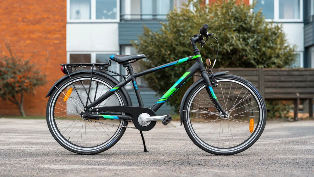 Sort børnecykel med blå og grønne detaljer – eksempel på en brugt børnecykel